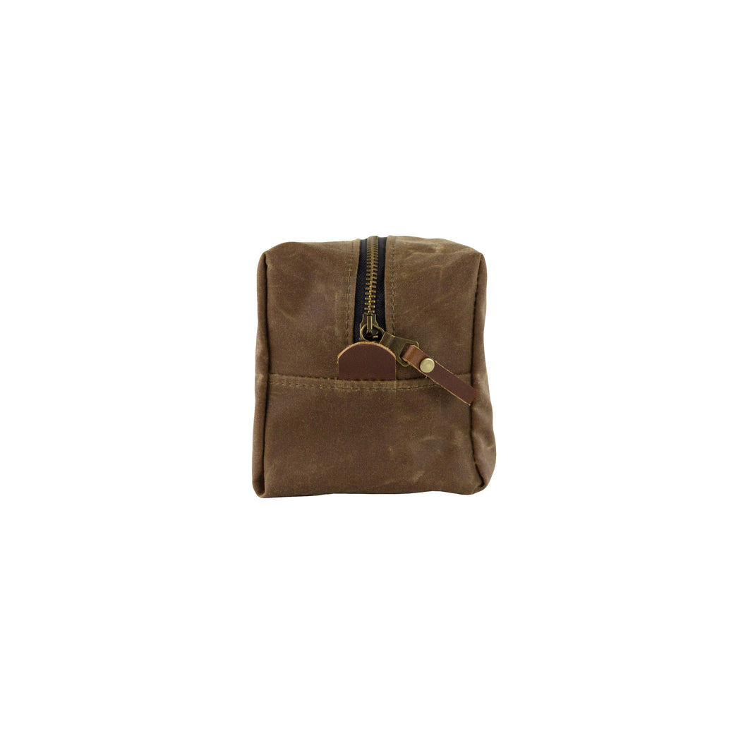 small waxed canvas dopp kit with vegetable tanned leather accents in tan - front view